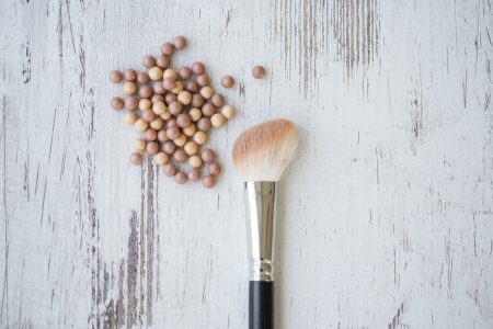 Blush beads and make-up brush, directly above shot.